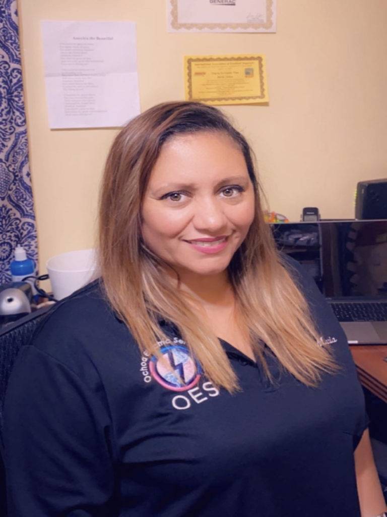 A Woman wearing an Ochoa Electric Services T-shirt in an office room